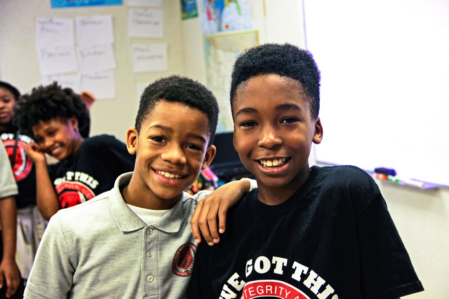 Two students smile at the camera.