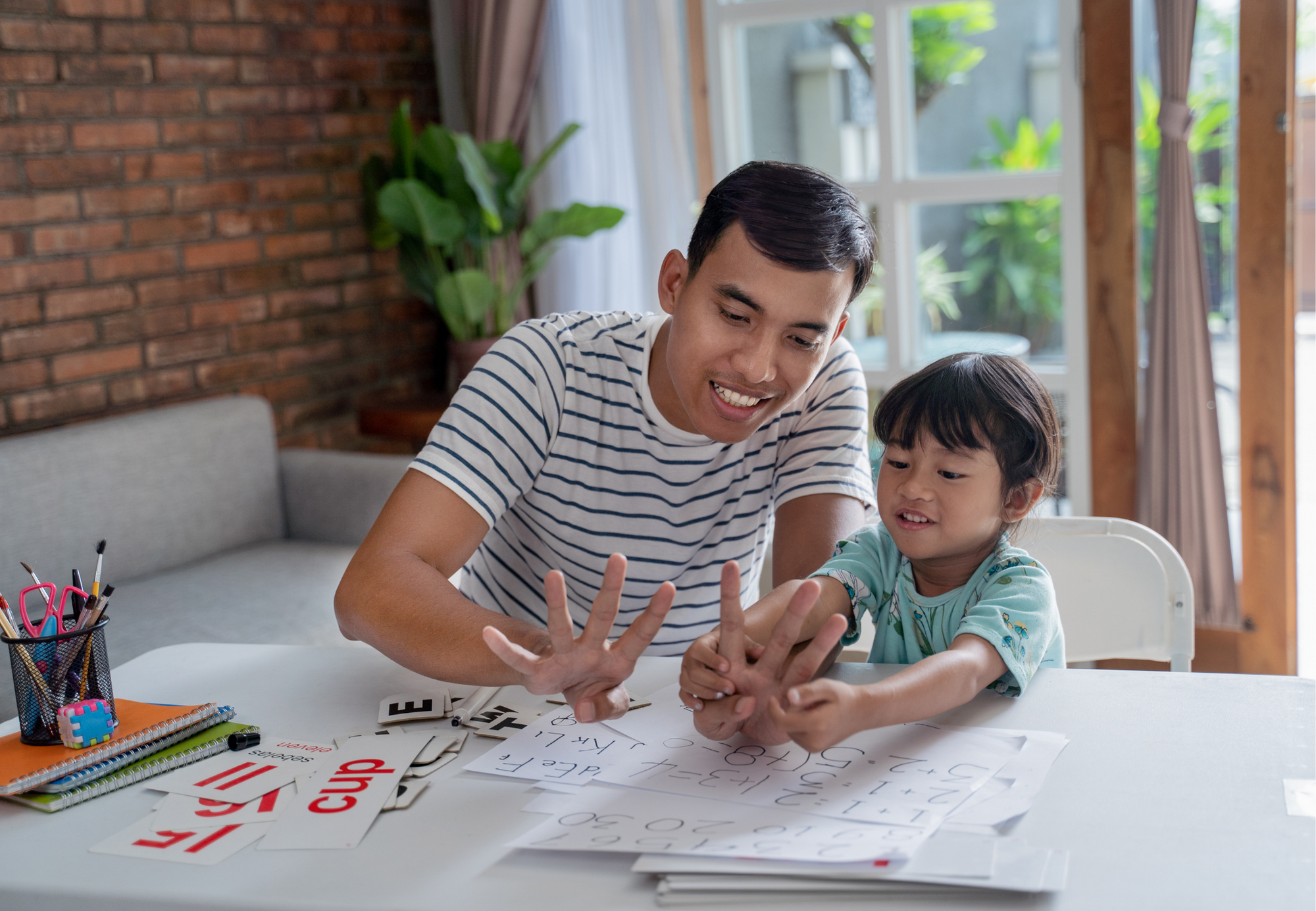 Parent holds up fingers for child to count. 